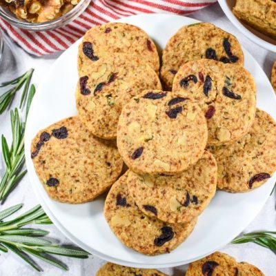 Holiday Cranberry Shortbread Cookies on White Serving Plate Surrounded by Sprigs of Thyme