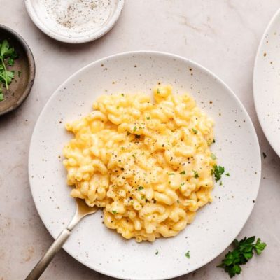 Gluten-Free Smoked Gouda Mac & Cheese on Round Stoneware Plate on Light Stone Counter