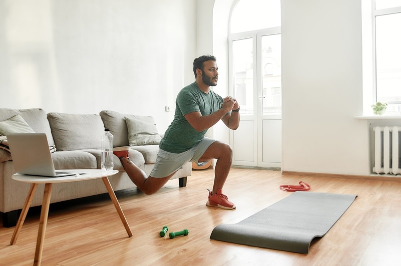 A Man Performs an At-Home Workout Routine, Representing Signs Your Workout is Not Working.