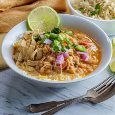 White Bean Chicken Chili With Toppings in Round, White Bowl on Marble Counter