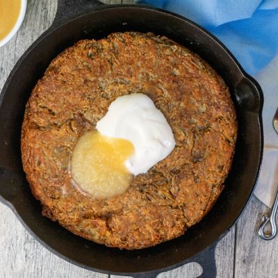 An Overhead View of a Giant Skillet Latke With Applesauce and Sour Cream.