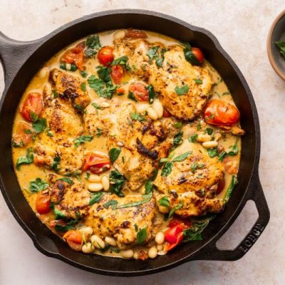 Creamy Tuscan Chicken With White Beans, Spinach and Tomatoes in Cast Iron Skillet