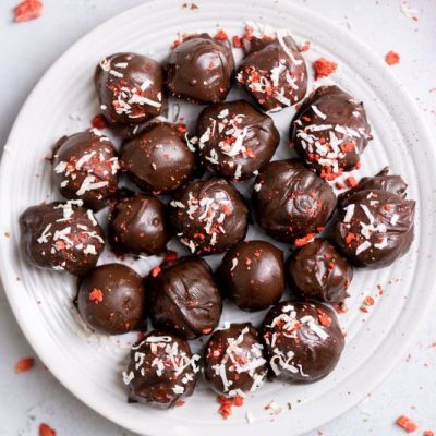 Dark Chocolate Strawberry Truffles Arranged on a Round Plate With Sprinkles of Coconut Flakes & Crushed Freeze-Dried Strawberries