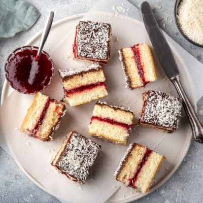 Overhead Shot of Gluten-Free Lamington Cake Squares With Berry Filling on a Round Serving Plate
