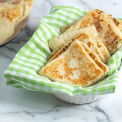 Irish Potato Bread in Basket Lined with Green Gingham Napkin on a White Marble Counter