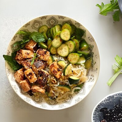Sesame Salmon Noodle Bowl With Pickled Cucumbers on Light Gray Countertop