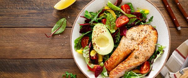 A Plate With Salmon, Avocado Mixed Greens and Vegetables Represents ADHD and Diet.