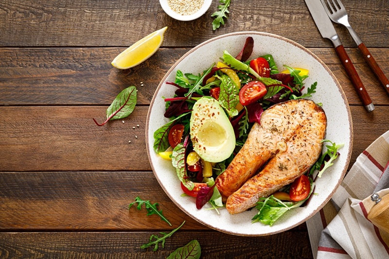 A Plate With Salmon, Avocado Mixed Greens and Vegetables Represents ADHD and Diet.