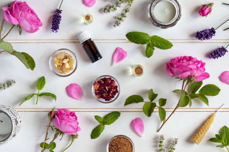 DIY Flower Perfume - A Healthy and Affordable Alternative Overhead View of Fresh Flowers, Leaves and Essentials Oils to Make Your Own Flower Perfume Oil