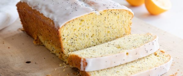 A Lemon Poppyseed Loaf Made with Einkorn Flour is Sliced and on a Cutting Board.