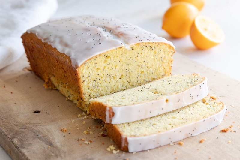 A Lemon Poppyseed Loaf Made with Einkorn Flour is Sliced and on a Cutting Board.