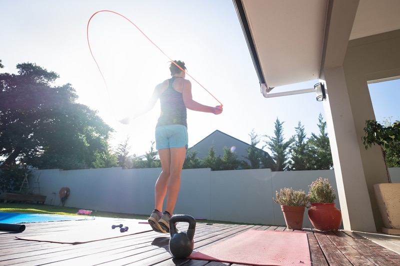 A Woman Jumps Rope on Her Deck, Representing the Question, "What Are Plyometrics?"