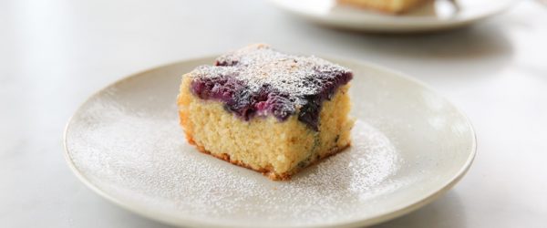 A Slice of Blueberry Yogurt Cake Made With Einkorn Flour Sits on a Small, White Cake.
