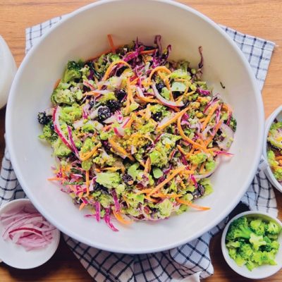 A Serving Bowl is Filled With Broccoli Slaw and Broccoli Slaw Dressing.