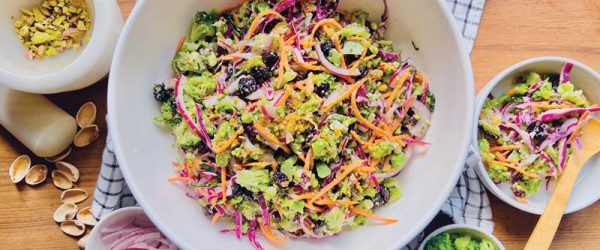 A Serving Bowl is Filled With Broccoli Slaw and Broccoli Slaw Dressing.