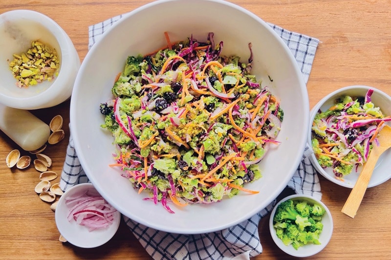A Serving Bowl is Filled With Broccoli Slaw and Broccoli Slaw Dressing.