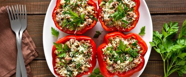 Four Lentil Stuffed Peppers Are Topped With Fresh Sprigs of Parsley.