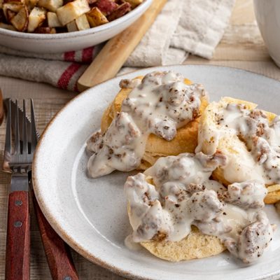 A Plate of Three Vegan Biscuits is Covered With Vegan Mushroom Gravy.