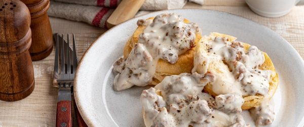A Plate of Three Vegan Biscuits is Covered With Vegan Mushroom Gravy.
