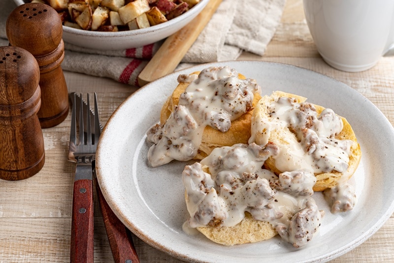 A Plate of Three Vegan Biscuits is Covered With Vegan Mushroom Gravy.