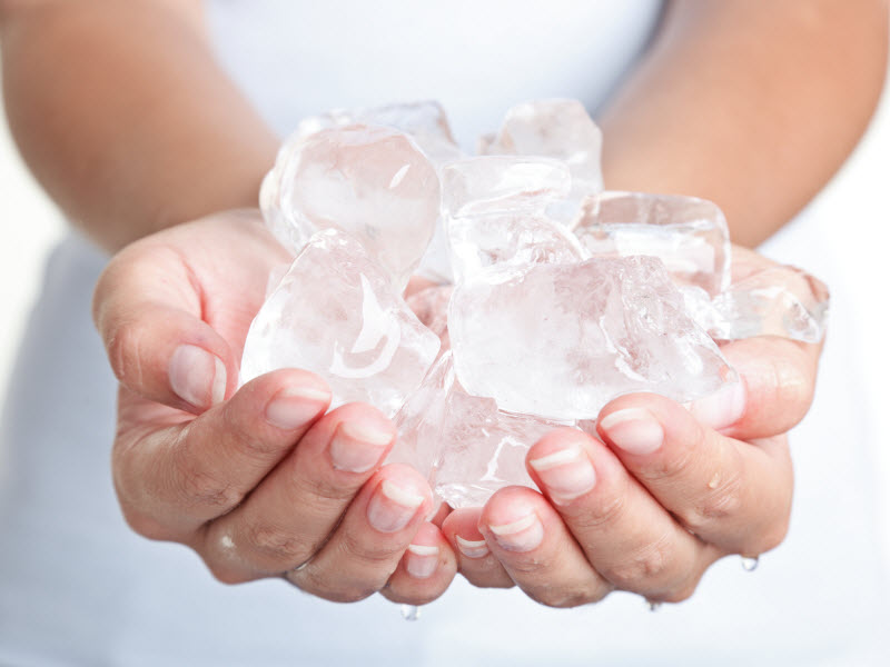 Woman Holding Ice Cubes in Cupped Palms to Represent Concept of What Does Icing Your Face Do