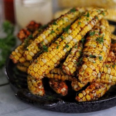 A Pile of Air Fryer Corn Ribs Are Stacked in a Black Serving Dish.