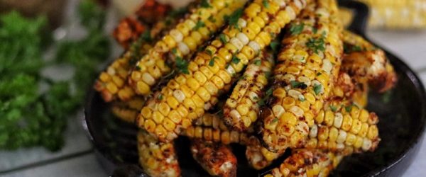 A Pile of Air Fryer Corn Ribs Are Stacked in a Black Serving Dish.