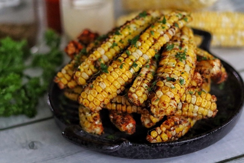 A Pile of Air Fryer Corn Ribs Are Stacked in a Black Serving Dish.
