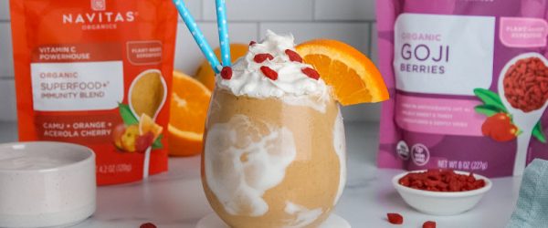 Orange Creamsicle Shake with Orange Slice, Goji Berries and Blue Straws Poking Out of Glass