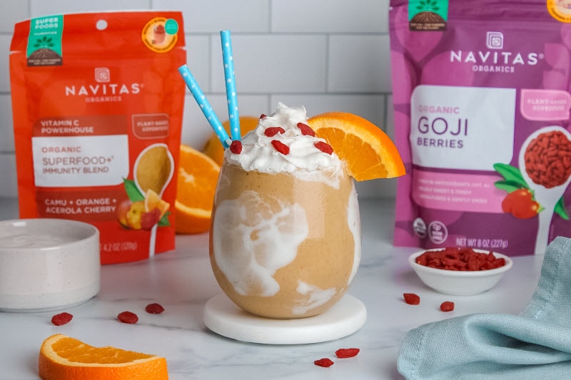 Orange Creamsicle Shake with Orange Slice, Goji Berries and Blue Straws Poking Out of Glass
