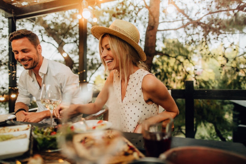 Concept of Sustainable Summer Represented by Happy Couple Hosting Dinner Party in Enclosed Patio