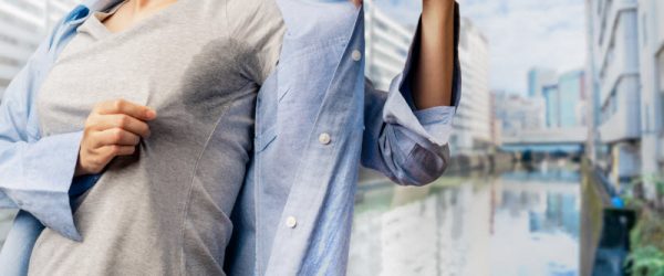 Woman Wondering Why Am I Sweating So Much Checking for Sweat Stain in Arm Pit of Shirt