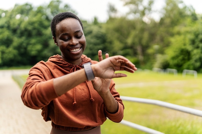 A Woman Checks Her Smart Watch While Taking on the 666 Walking Challenge.