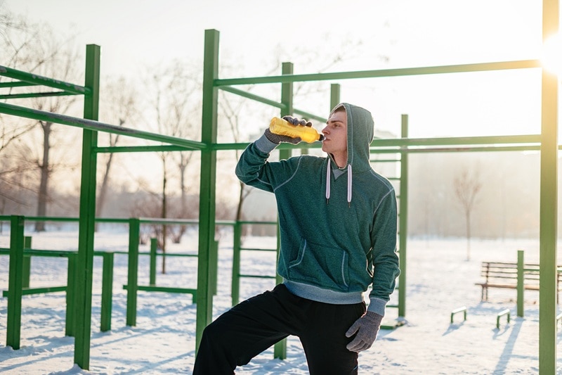 A Young Man Drinks an Energy Drink Before an Outdoor Workout.