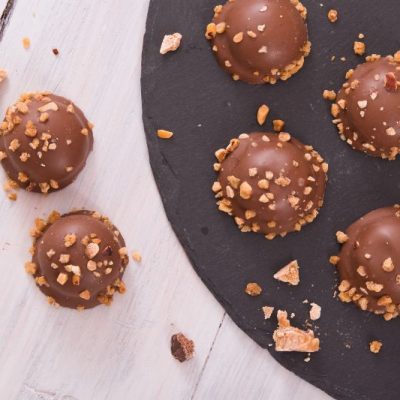 Chocolate-Covered Peanut Butter Truffles on Plate With Crushed Peanuts on Top