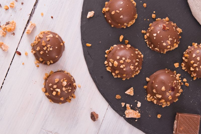 Chocolate-Covered Peanut Butter Truffles on Plate With Crushed Peanuts on Top