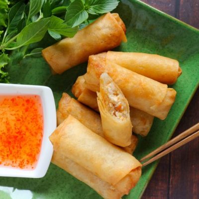 Golden Fried Spring Rolls on Rectangular Serving Plate with a Square Bowl of Spicy Sauce