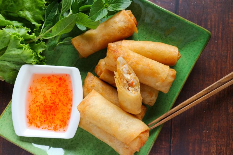 Golden Fried Spring Rolls on Rectangular Serving Plate with a Square Bowl of Spicy Sauce