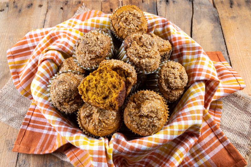 Gluten-Free Pumpkin Muffins with Sugar Sprinkles on Top in Linen Napkin-Lined Basket on Wood Table