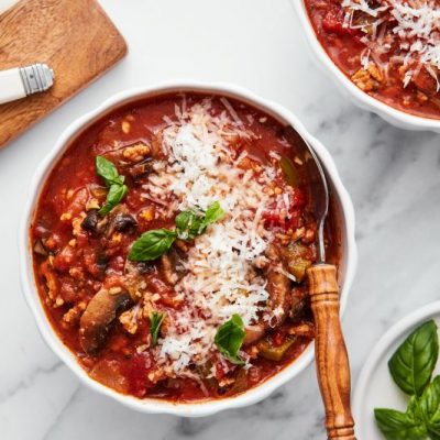 Pizza Soup With Turkey Sausage in Large Bowl Topped With Mozzarella and Basil