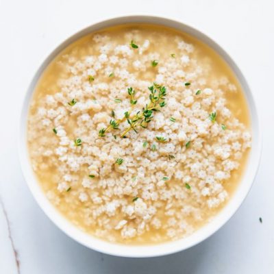 Stelline Soup with Star Pasta and Thyme Sprigs in Round Bowl on Marble Counter