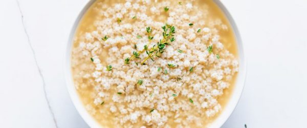 Stelline Soup with Star Pasta and Thyme Sprigs in Round Bowl on Marble Counter