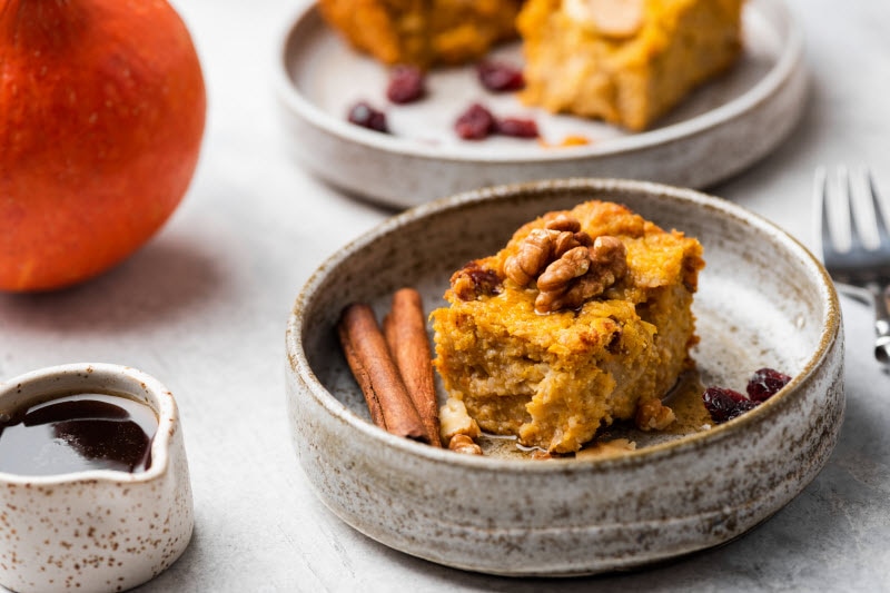 Pumpkin Cake Slice in Stone Bowl with Pumpkin on Table to Represent Concept of Pumpkin Puree Recipes