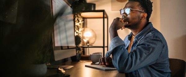 A Man Looks into the Blue Light of His Computer Screen, Representing Blue Light Exposure.