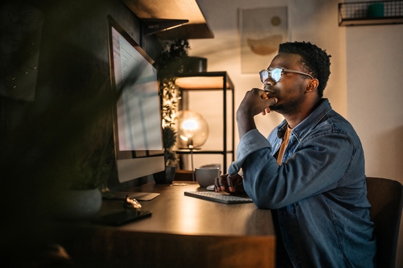 A Man Looks into the Blue Light of His Computer Screen, Representing Blue Light Exposure.
