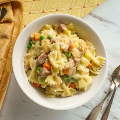 Big Bowl of Chicken Pot Pie Made with Bow-Tie Pasta in Round Bowl on Marble Counter