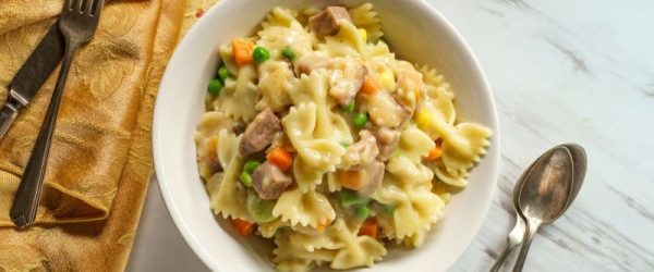 Big Bowl of Chicken Pot Pie Made with Bow-Tie Pasta in Round Bowl on Marble Counter