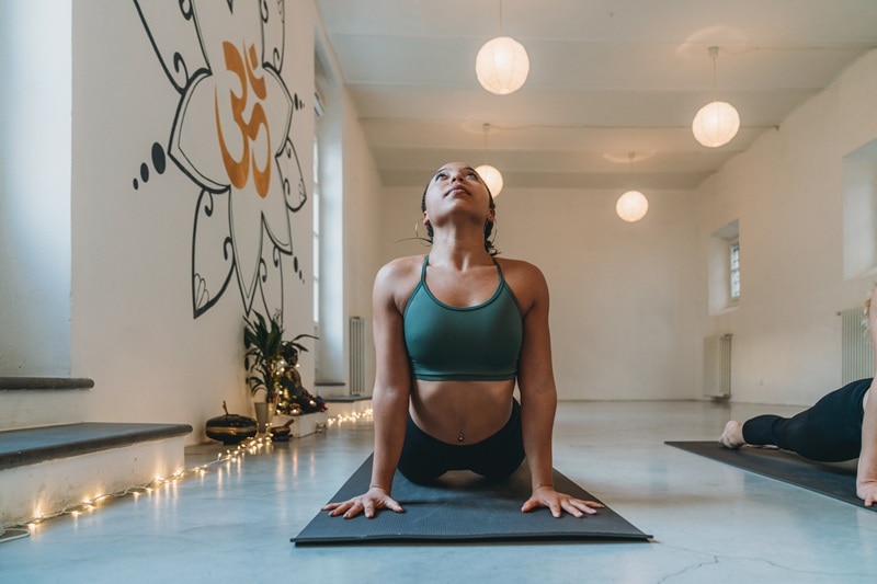 A Woman Performs a Yoga Pose in a Studio, Representing a Hot Exercise Workout.