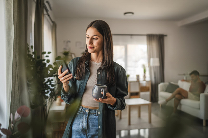 Woman Undergoing EMF Exposure Using Home Wifi to Connect Wirelessly to the Internet in Her Living Room