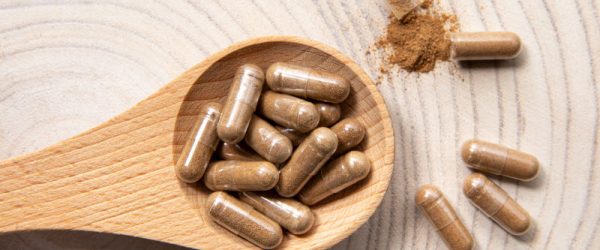 How to Make Your Own Supplements - A Step-by-Step Guide Concept of How to Make Your Own Supplements Represented by Capsules Filled with Beige Powder on Wooden Spoon on Wood-Grain Background